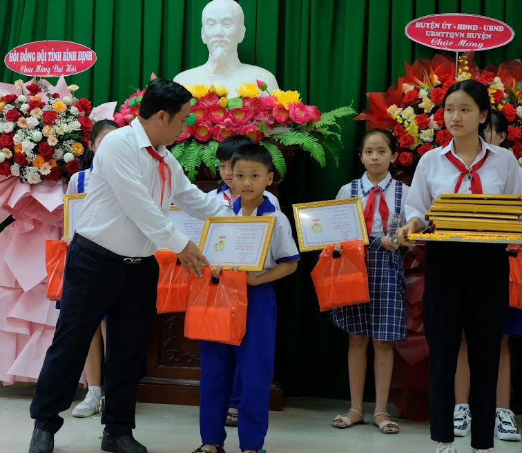 Đồng chí Huỳnh Văn Duy - Chủ tịch Hội Nông dân huyện Hoài Ân tặng quà cho các em học sinh nhân dịp Đại hội Cháu ngoan Bắc Hồ năm 2024